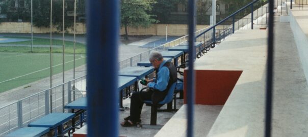 a man sitting on a bench at a baseball field